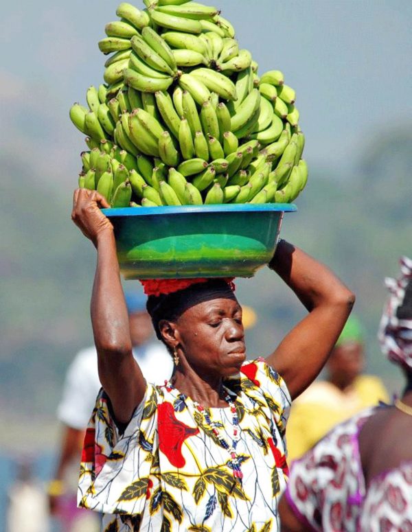 Woman carrying fruit on head - Guinea tours and holidays