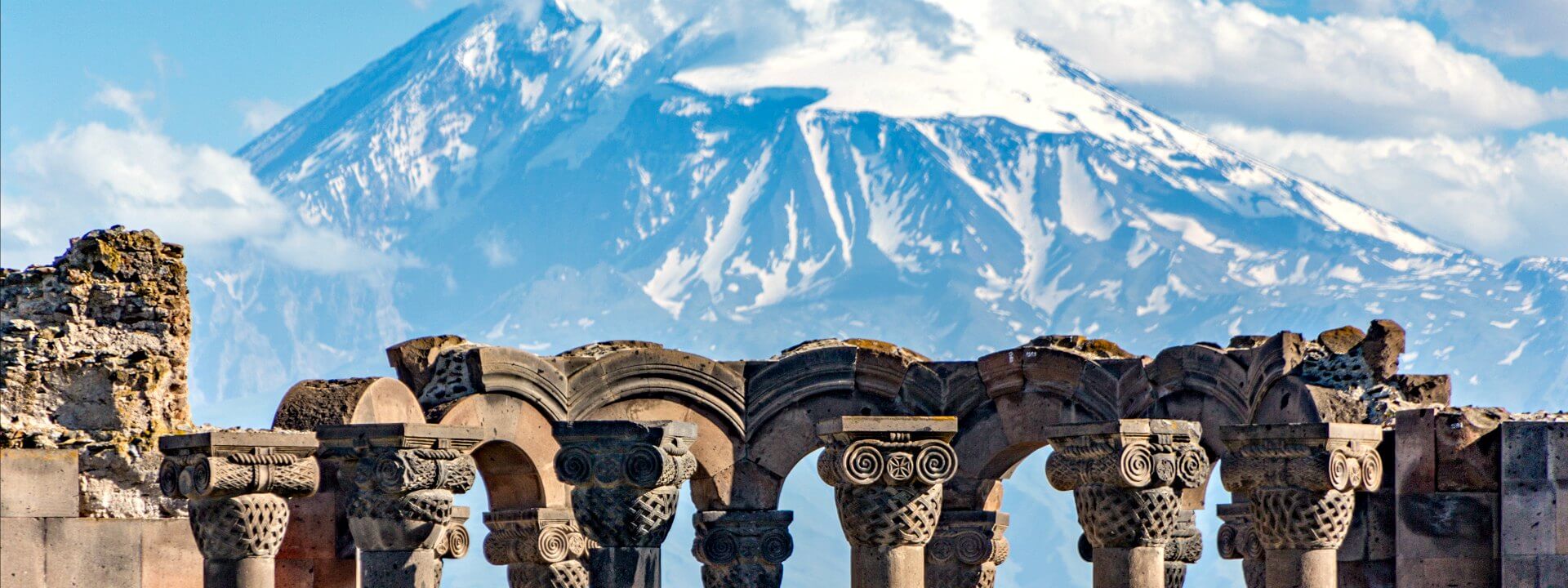 Alternative Europe holidays - Armenia - ruins in front of snow-capped mountain