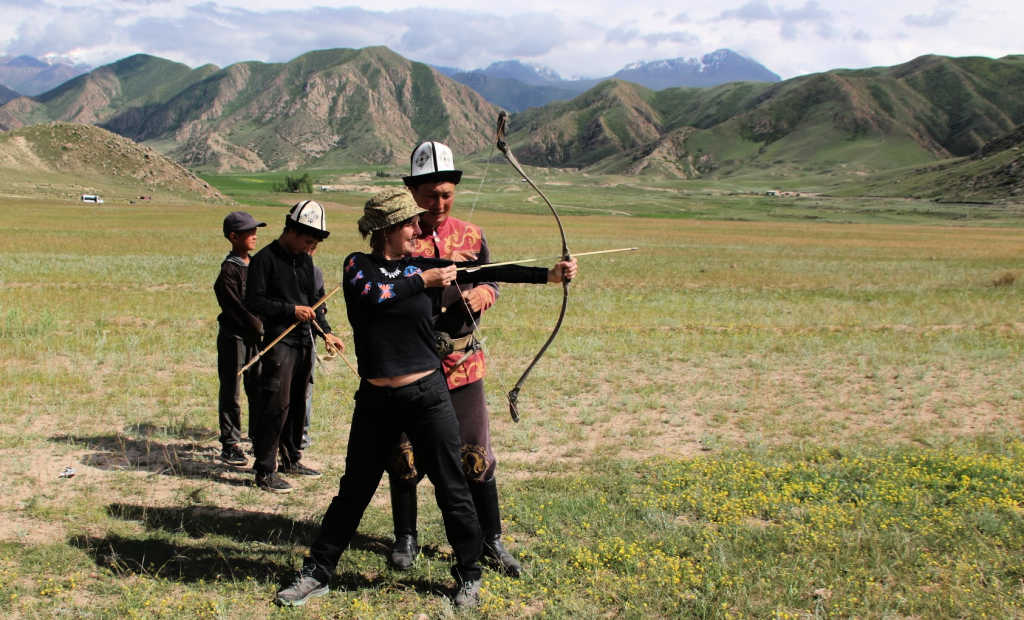 Chelsea in Kyrgyzstan learning to use a traditional bow and arrow